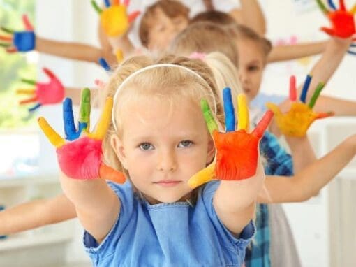 Children with a leader with painted hands during an art class