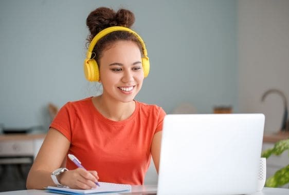 Lady wearing headphones looking at her laptop