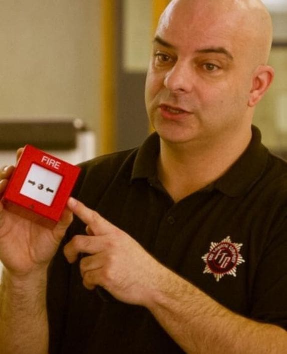 Nick the fire trainer demonstrating how a fire alarm works.