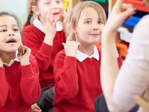 Pupils copying their teacher at the front of the class