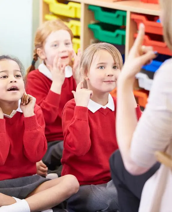 Pupils copying their teacher at the front of the class