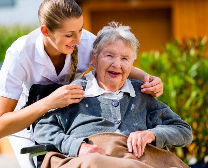 Older lady in a wheelchair with her carer