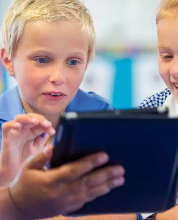 Boy interacting with a tablet in a classroom