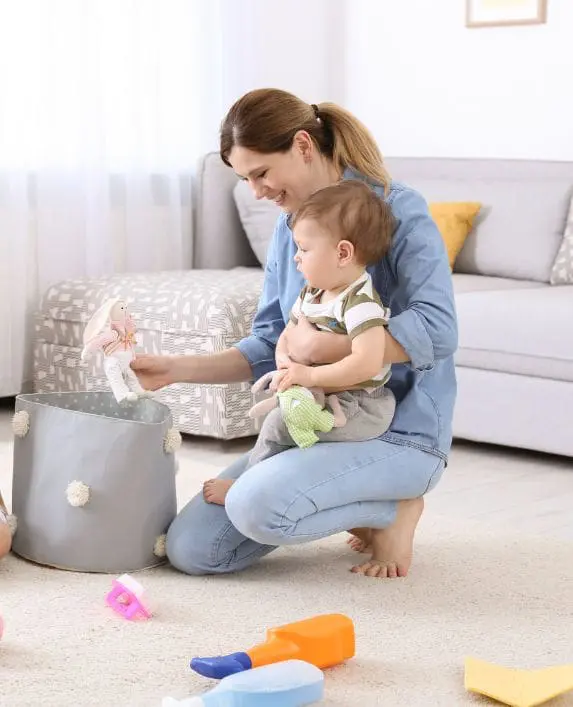 Childminder playing with a baby in her home.