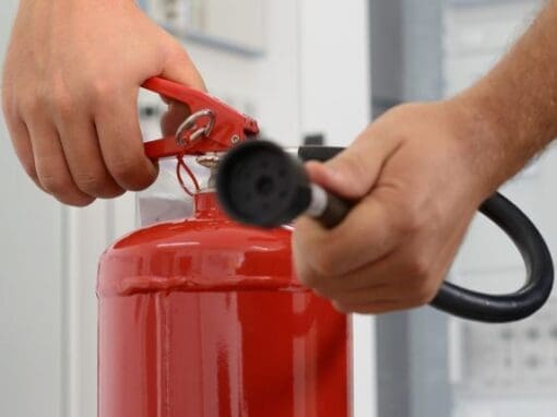 Somebody demonstrating the use of a fire extinguisher