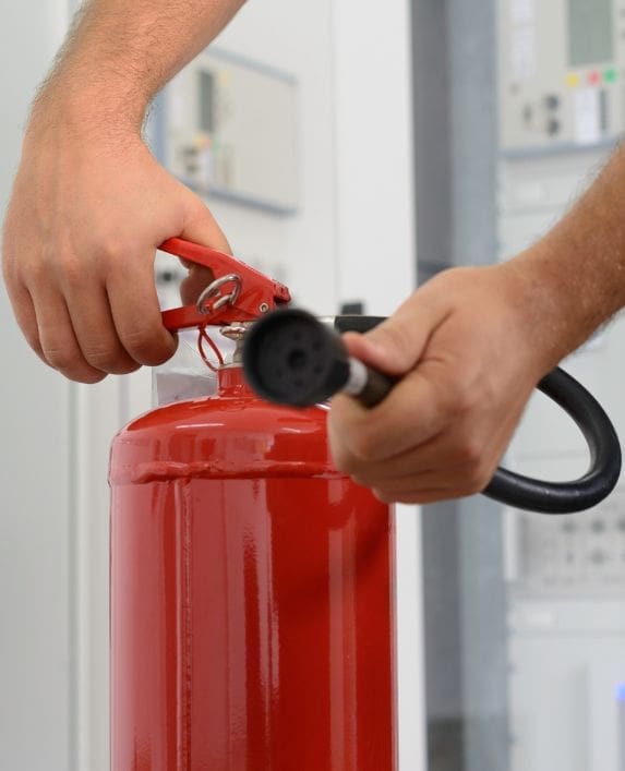 Somebody demonstrating the use of a fire extinguisher
