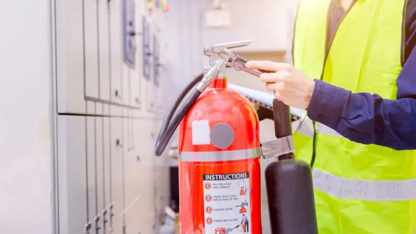 Fire warden checking a fire extinguisher
