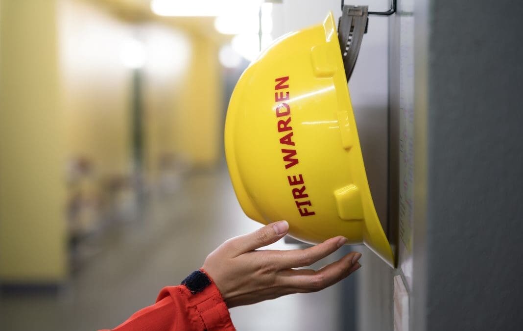 Fire warden hat with somebody reaching for it.