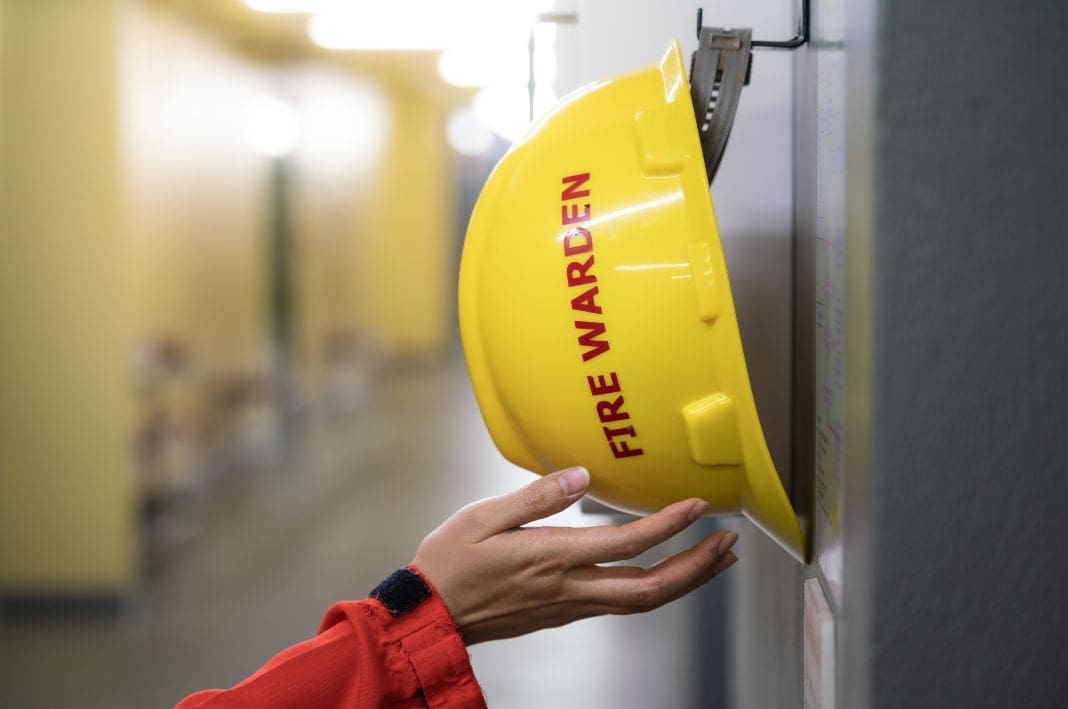 Fire warden hat with somebody reaching for it.