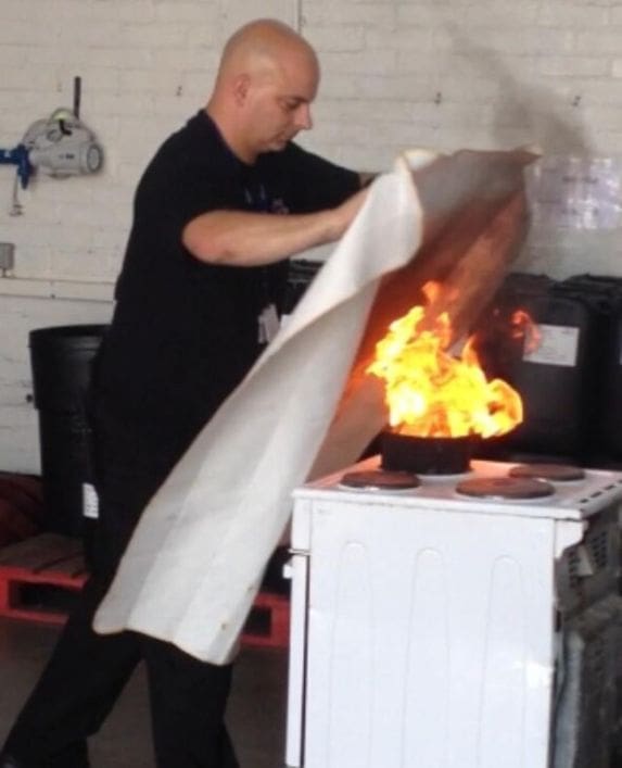 Fire Trainer demonstrating the use of a fire blanket