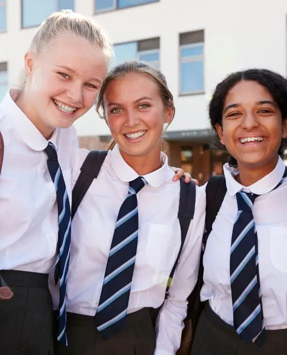 Three pupils looking at the camera in their school uniform