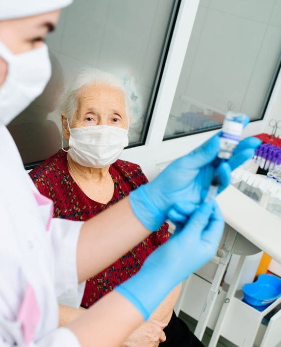 A lady being very careful with the control and prevention of infection by wearing a mask, gloves etc.