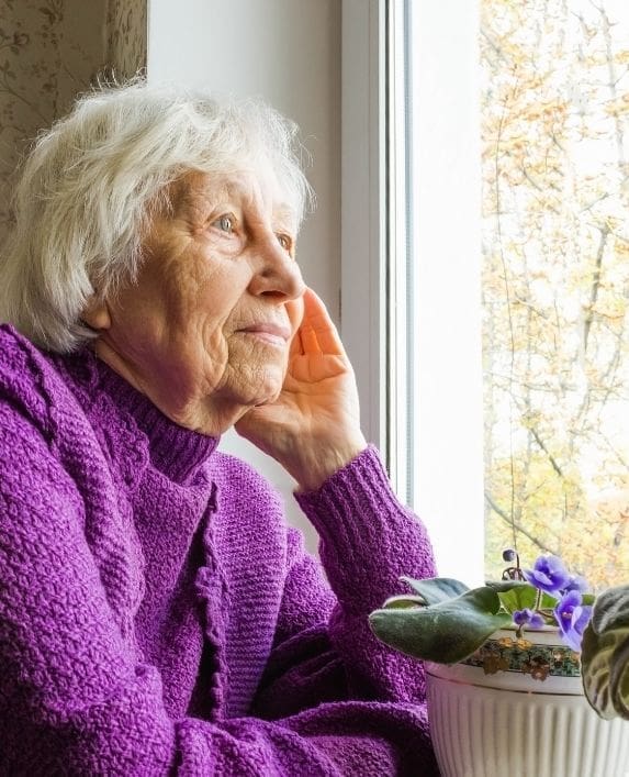 Elderly lady looking out of the window