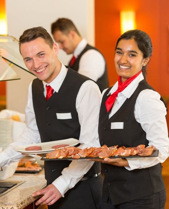 Picture of some smart servers serving food.