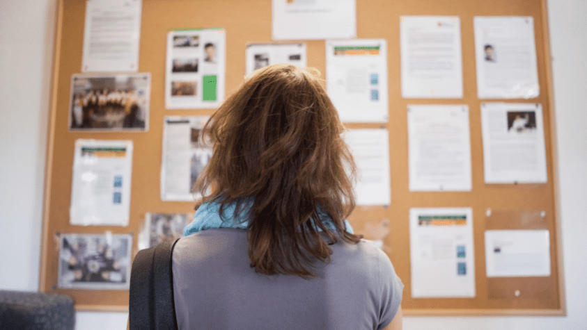 A safeguarding policy on a notice board that a volunteer is looking at.